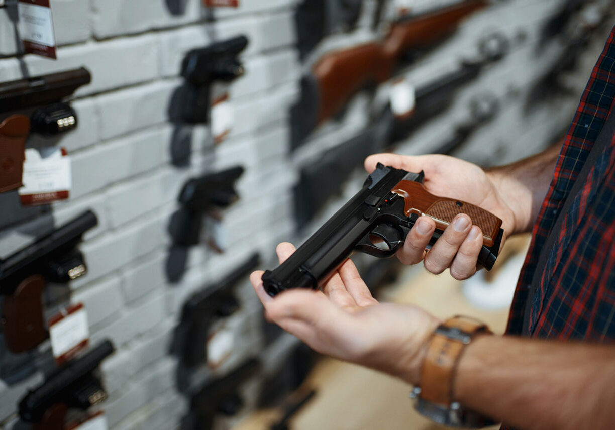 Hands holding gun at gun shop