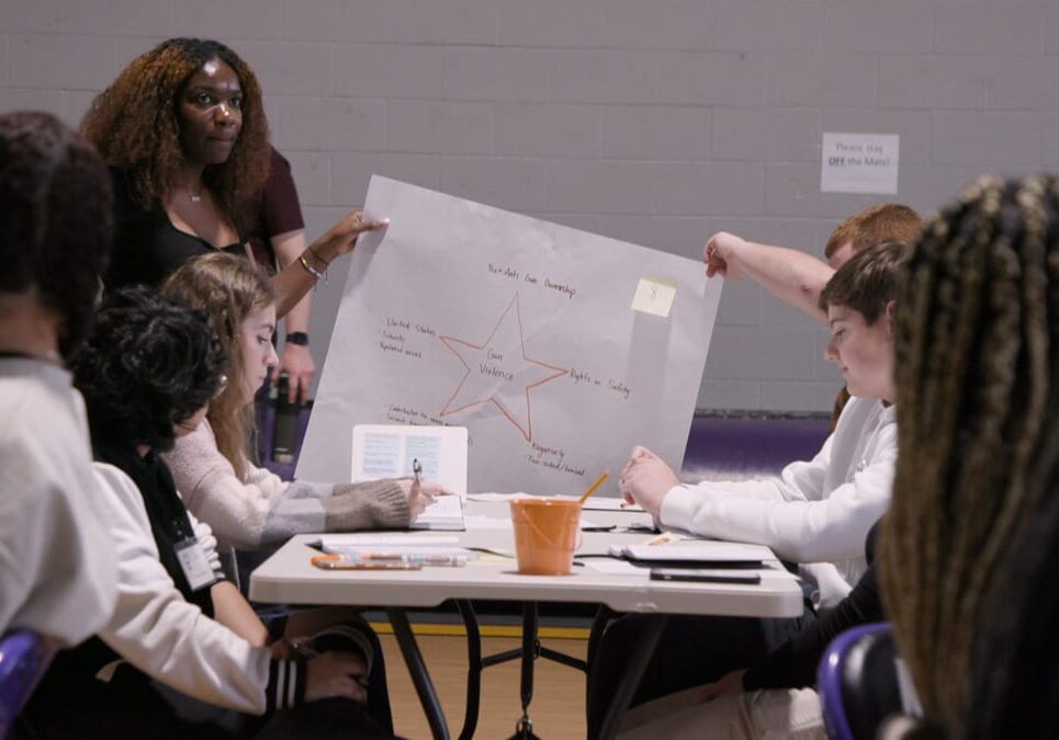 Students hold up a poster with a star in the middle and notes written all around it.