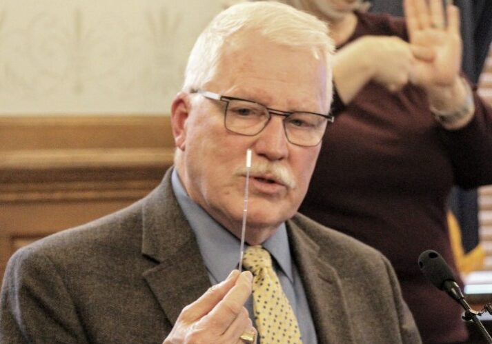 Kansas Health Secretary Lee Norman displays a swab used for COVID-19 testing.