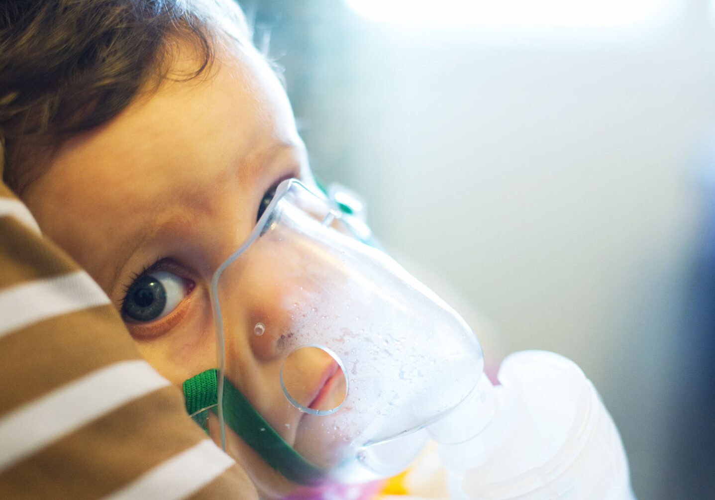A young child with a oxygen mask on looks into the camera. Pediatric health is taking a hit, in more ways than one parents and doctors say. (Adobe)