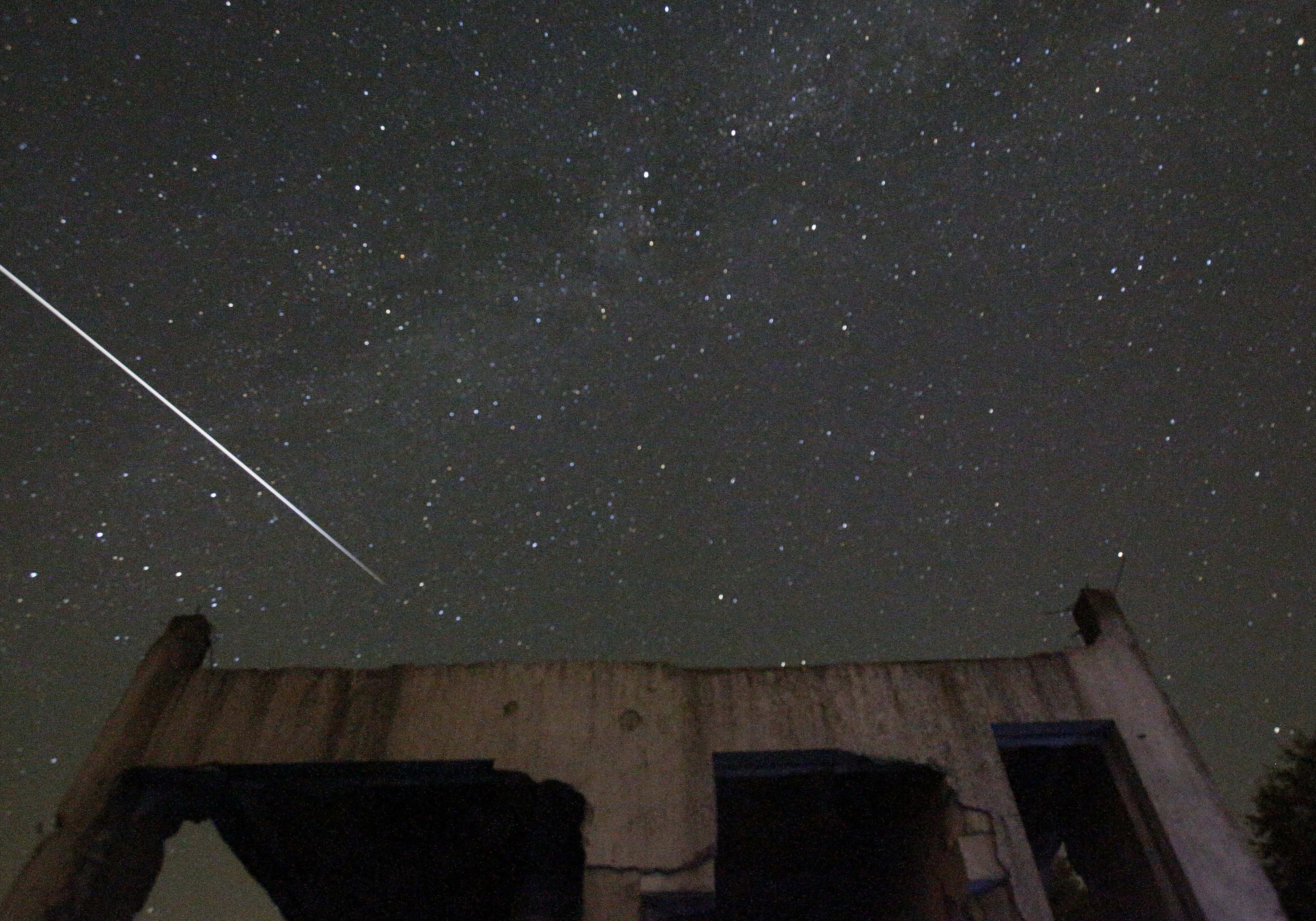 Stars and Perseid meteor streaks are seen behind a destroyed house near Tuzla, Bosnia, in 2015.