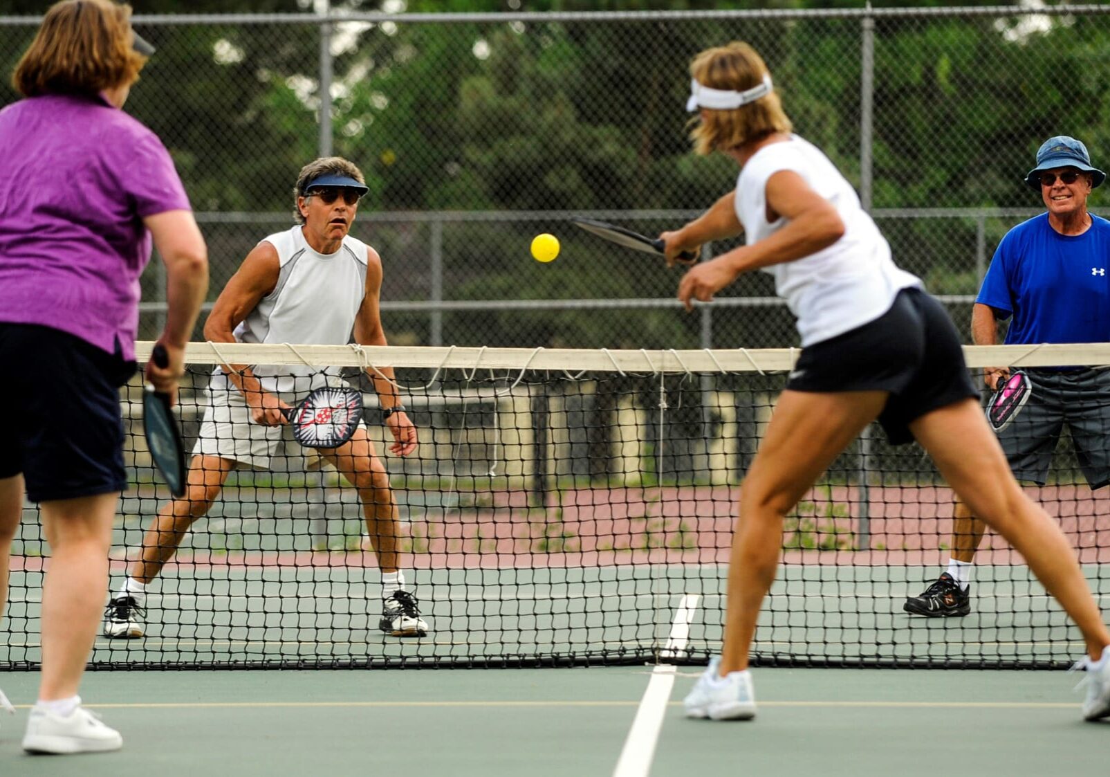 Val Olson (from left), Rick Kamm, Steve David and Dee Haskins play up to the net during a pickleball game at Monument Valley Park in Colorado Springs, Colo., in 2011.