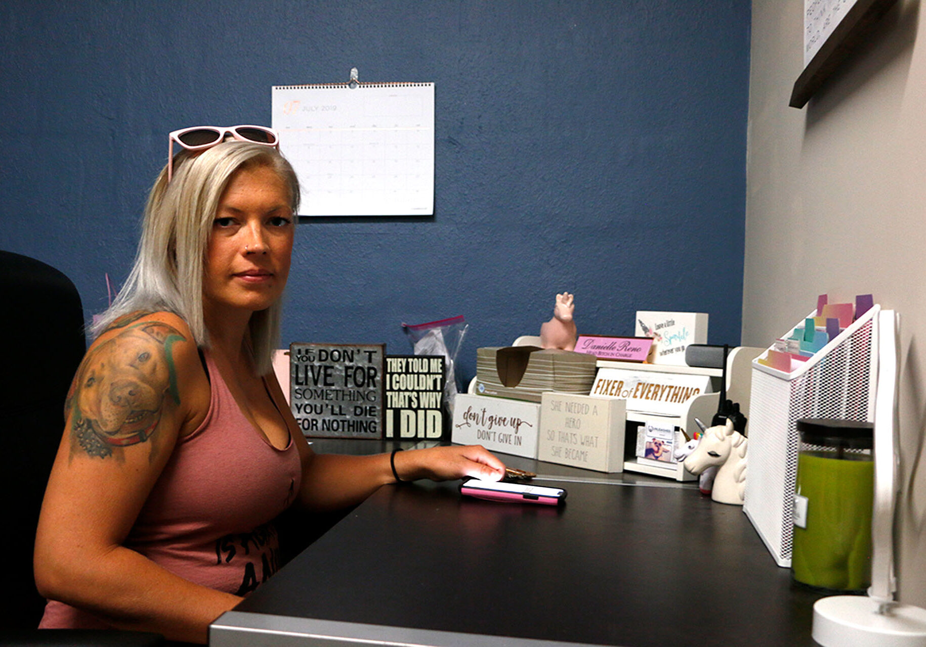 Danielle Reno sits at a desk in her office