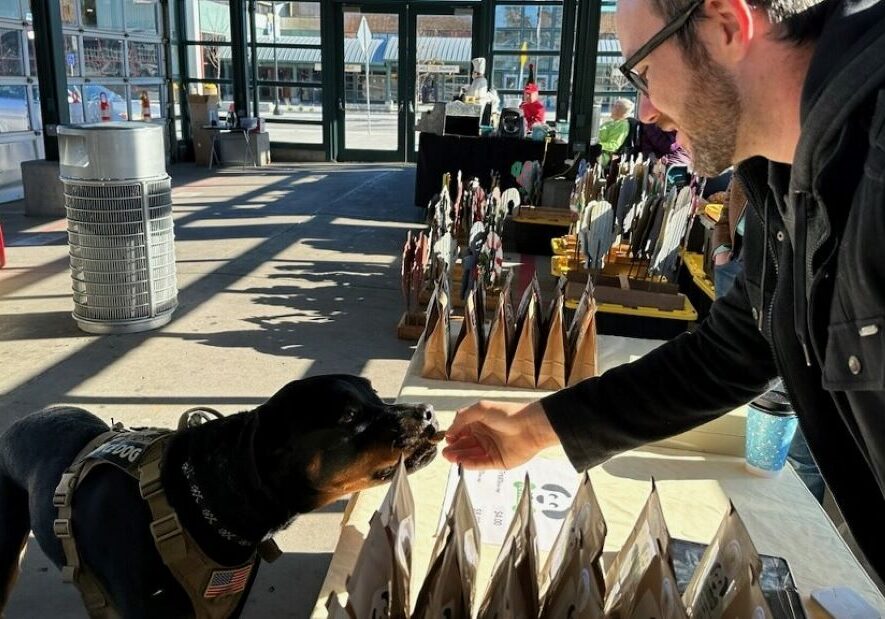 Older Youth Case Manager Joe Brecht shares samples of reTreats gourmet dog treats at The City Market on a Sunday morning.