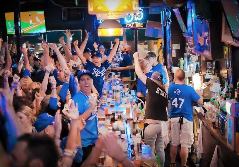 Fans celebrate in a crowded bar.