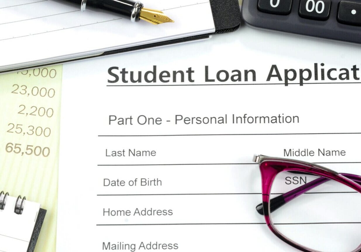 Applying for student loan. Filling up the loan form with calculator, pen, note pad on the desk