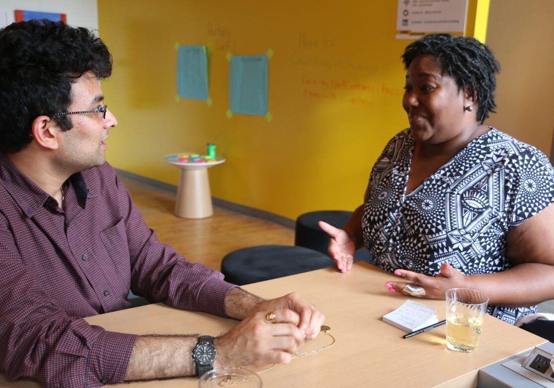 Catina Taylor talks with Aditya Voleti at a meeting