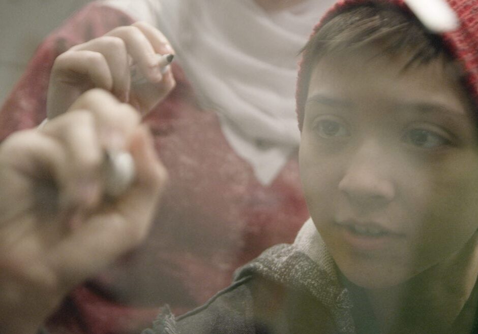 a boy writing on a board