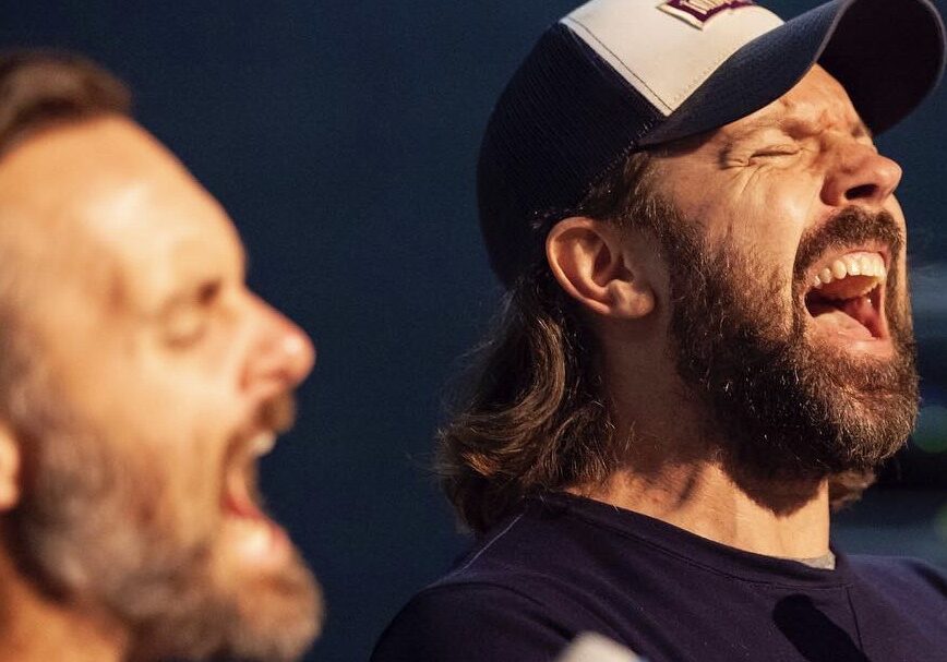 Jason Sudeikis sings into a microphone