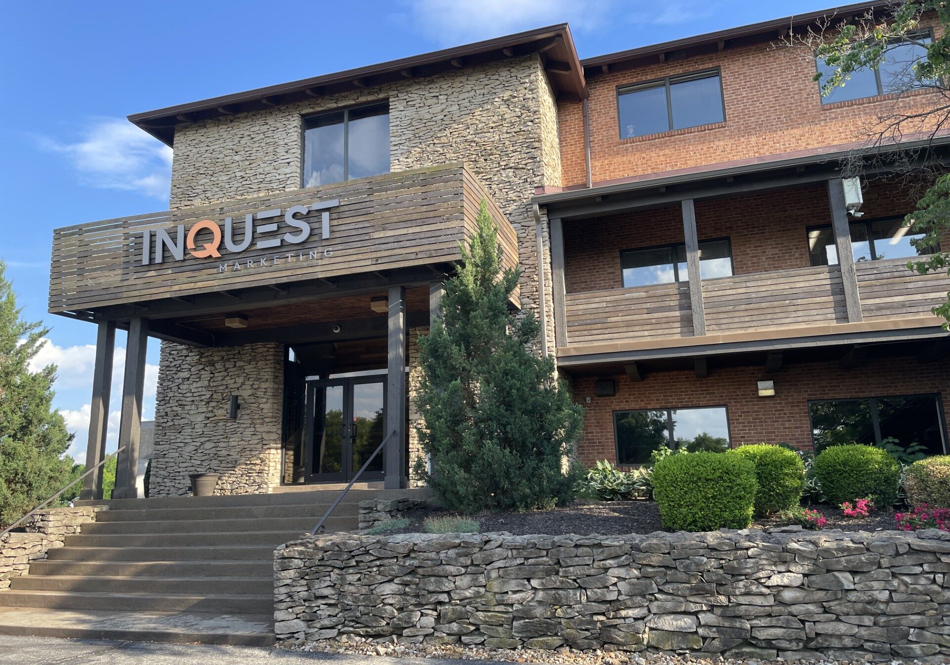 Stone and brick building INQUEST lettering on front, concrete steps