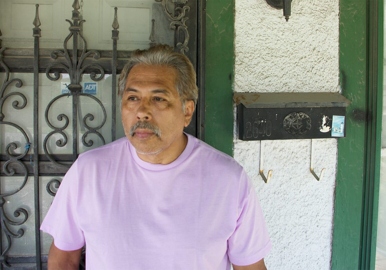 Tom Ribera stands in front of a house he is rehabbing