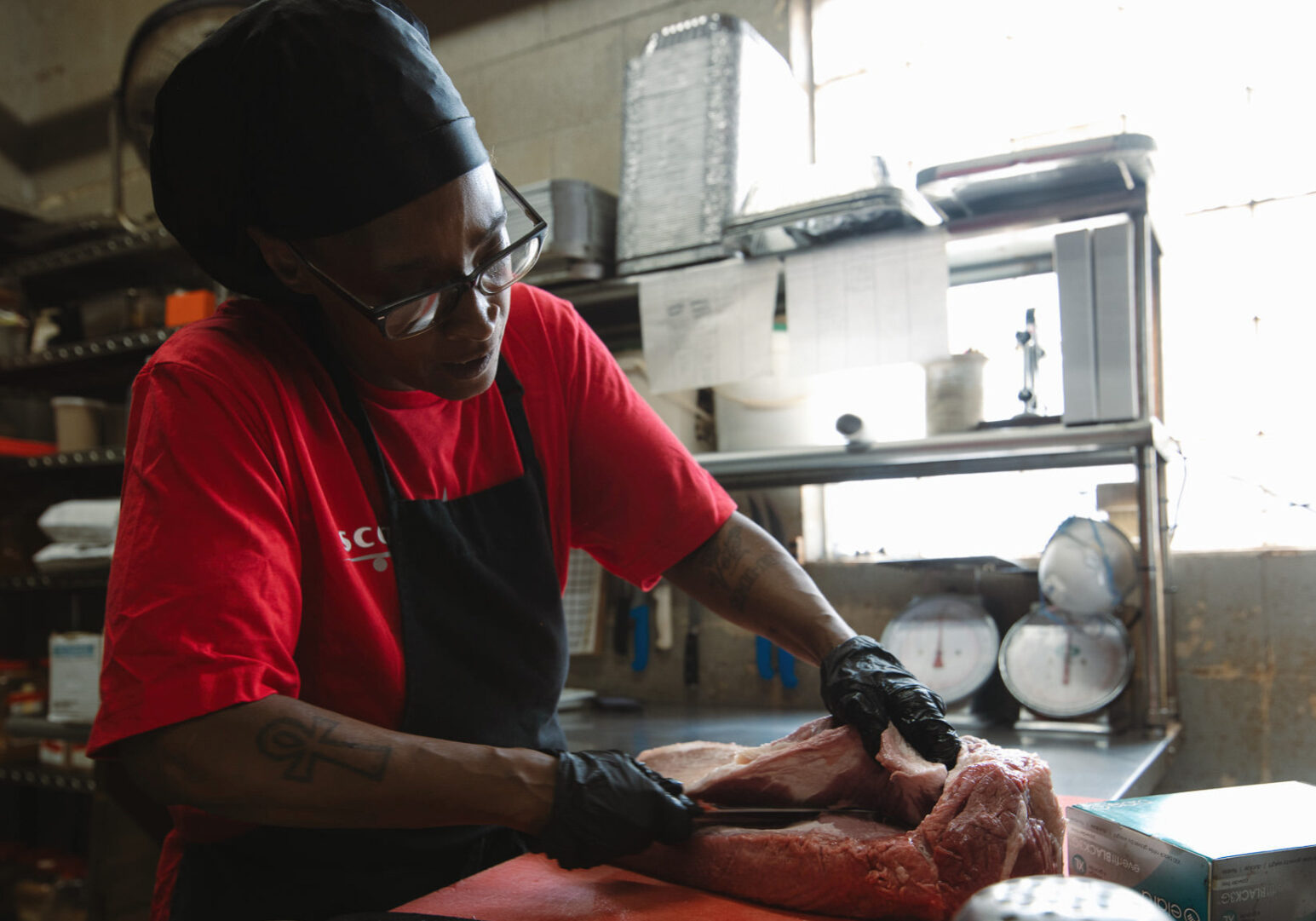 Veronica Scroggins trims beef for brisket at Scott’s Kitchen & Catering at Hangar 29 in Kansas City, North. (Chase Castor | Flatland)