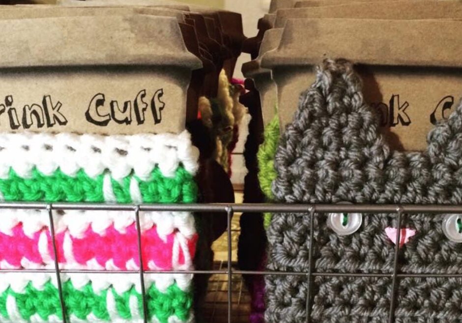 Knitted koozies, one in the shape of a cat.