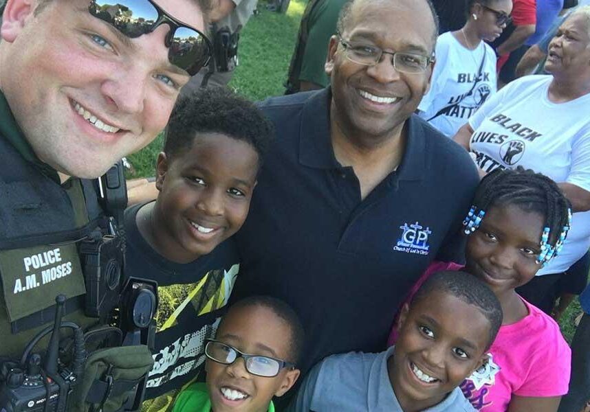 A Wichita police officer poses with residents at the First Steps Community Cookout on Sunday.